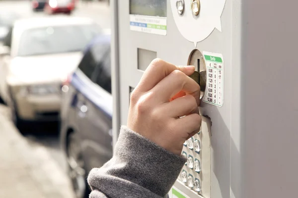 주차 미터에 동전을 삽입 하는 한 인간의 손으로. — 스톡 사진