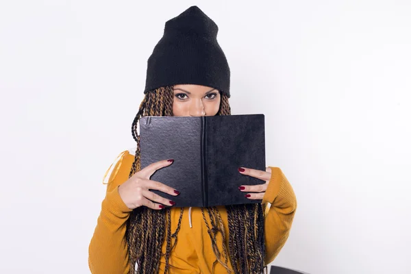 Gülümseyerek, kara kitap saklanıyor kadın