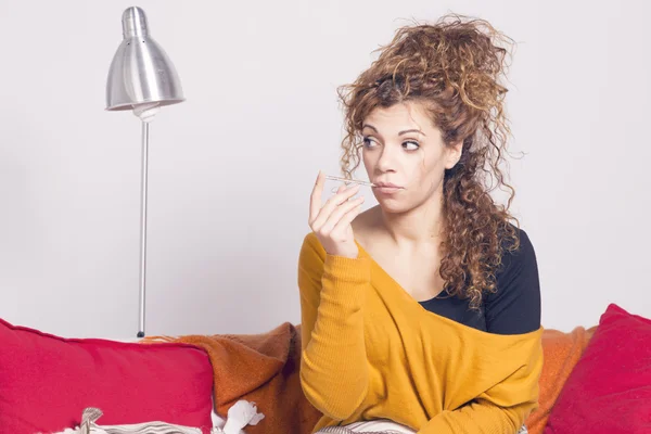 Zavallı hasta bir kadın, bir termometre ile ateşi alarak.