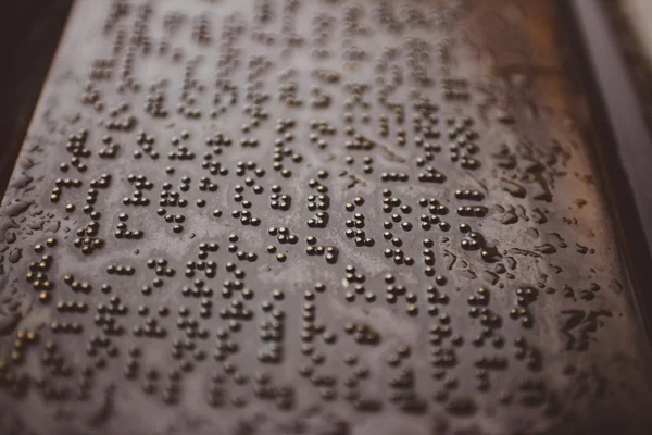 Kelimeler dokun. Braille noktalar arka plan ile metal levha