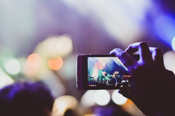 Girl recording video with smartphone during a concert — Stock Photo, Image