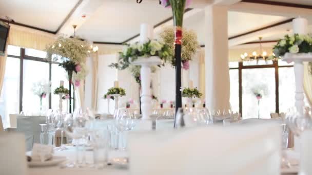 Свадьба Очень красиво украшенный стол Современный стиль. Красивые цветы на столе в день свадьбы с тарелками и салфетками — стоковое видео
