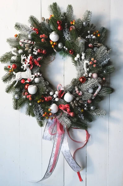 Corona de Navidad hecha a mano en puertas de madera blanca. .. Copiar espacio. Fondo hermoso de Navidad —  Fotos de Stock