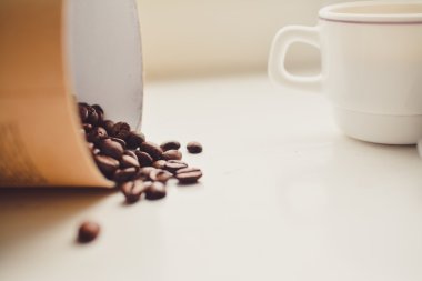 Kahve taneleri kağıt kap içinde. Beyaz arka plan