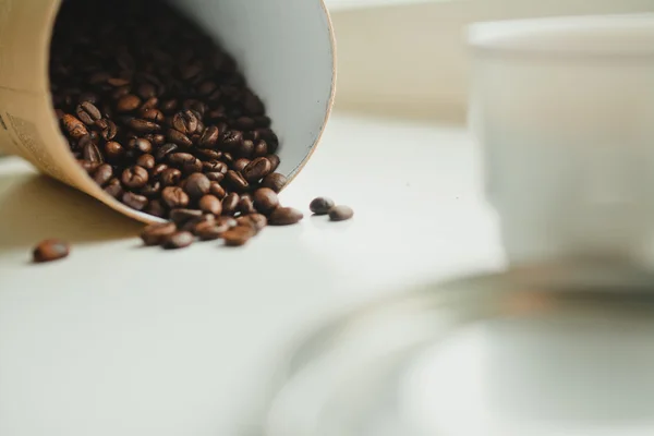 Granos de café en el contenedor de papel. Fondo blanco — Foto de Stock