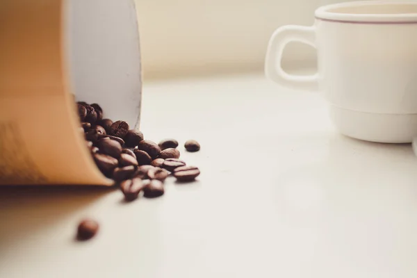 Granos de café en el contenedor de papel. Fondo blanco — Foto de Stock