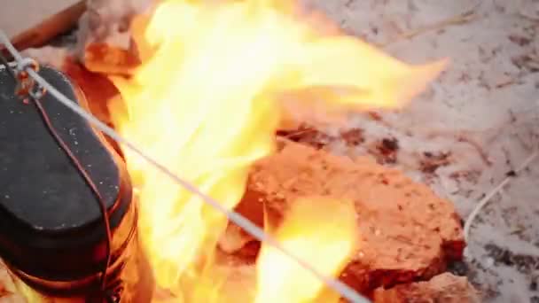 Preparación de la cena se cocina en una olla pequeña sobre un fuego abierto — Vídeos de Stock