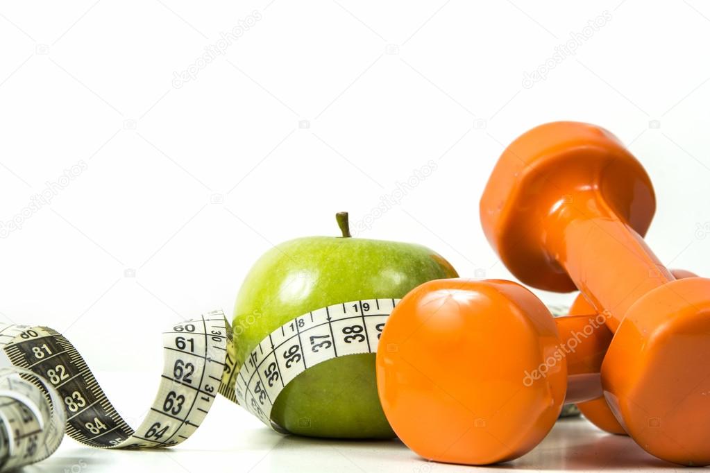 Green apple, tape measure and dumbbells