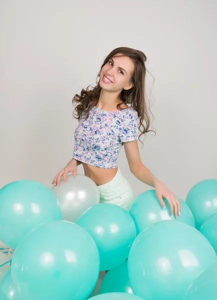Νεαρή όμορφη γυναίκα στο λευκό σορτς και πολύχρωμο κορυφή παιχνίδι με μπαλόνια, αργή κίνηση — Φωτογραφία Αρχείου