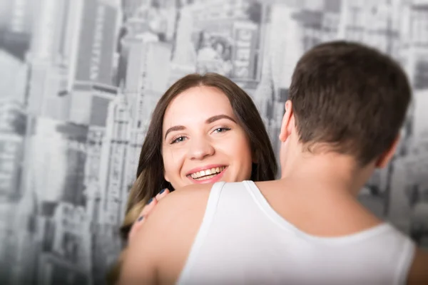 Feliz jovem casal desfrutando de um momento íntimo, rindo muito e o homem acaricia suavemente o cabelo de seus parceiros — Fotografia de Stock