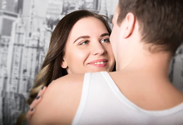 Feliz jovem casal desfrutando de um momento íntimo, rindo muito e o homem acaricia suavemente o cabelo de seus parceiros — Fotografia de Stock