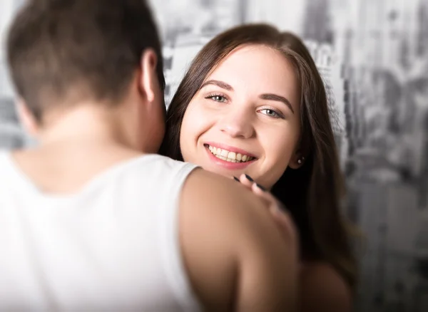 Feliz jovem casal desfrutando de um momento íntimo, rindo muito e o homem acaricia suavemente o cabelo de seus parceiros — Fotografia de Stock