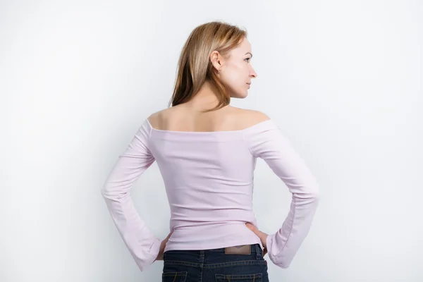 Beautiful young leggy blonde in a bright blouse with bare shoulders, turned away from the camera, showed its face in profile — Stock Photo, Image