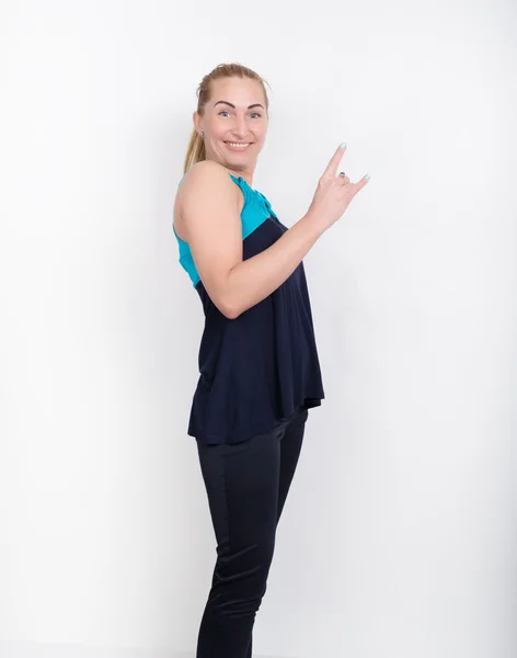 Красива блондинка в спортивній сорочці, чорні шорти і кольорові кросівки позує, показуючи великі пальці вгору жест — стокове фото