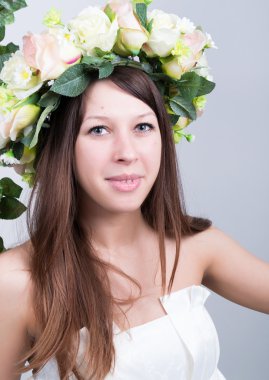 Küçük beyaz elbiseli, salıncakta salıncak sallanan, halatla sarmaş dolaş sarmaşık sarmaşık sarmaşık sarmaşığı. Kafasında çiçek çelengi olan kız. bahar havası