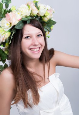 Küçük beyaz elbiseli, salıncakta salıncak sallanan, halatla sarmaş dolaş sarmaşık sarmaşık sarmaşık sarmaşığı. Kafasında çiçek çelengi olan kız. bahar havası