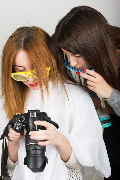 Красивая молодая рыжеволосая модель выглядит на камеру, парикмахер делает прическу. две девушки в очках диско — стоковое фото