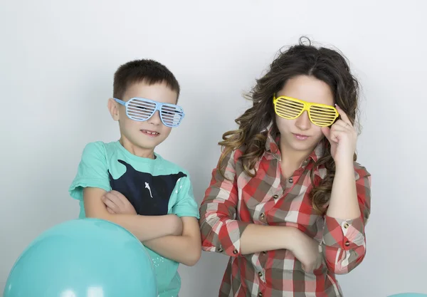 Brother and sister, wearing glasses in the style of disco. fold ones arms — 图库照片