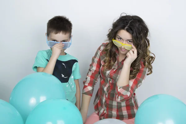 Brother and sister, wearing glasses in the style of disco. fold ones arms — 图库照片