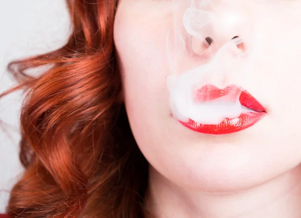 Close-up portrait of a elegant young redhead woman, bright red lips, the smoke releases — Stock Photo, Image