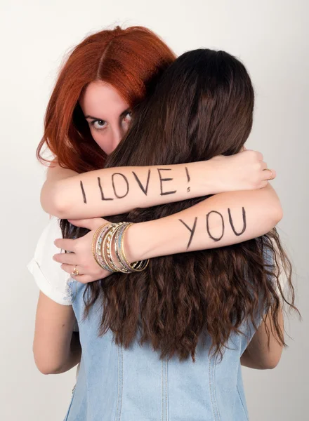拥抱她的朋友，在她的红头发女孩武器铭文我爱你 — 图库照片