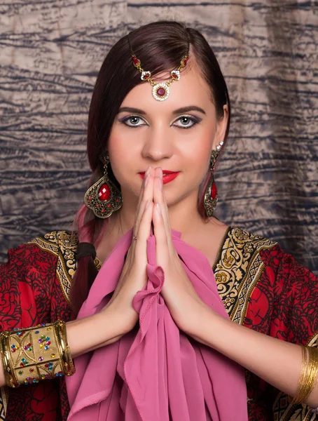 Primo piano di Bella donna caucasica vestita in stile orientale con motivi orientali sulle mani e sul viso, con numerosi bracciali. Indiano donna facendo namaste mani segno — Foto Stock