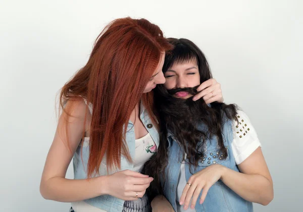 Δύο νεαρές φιλενάδες υποκύπτω, κάνουν ο ένας τον άλλο μουστάκι από τα μαλλιά. Έφηβος που φτιάχνει μουστάκι από τα μαλλιά — Φωτογραφία Αρχείου