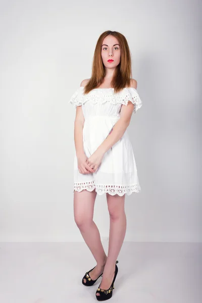Menina fina bonita em um pequeno vestido de renda branca posando — Fotografia de Stock