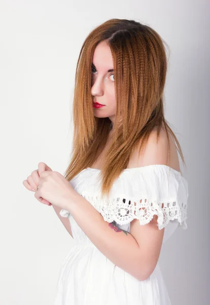 Schöne schlanke Mädchen in einem kleinen weißen Spitzenkleid posiert — Stockfoto