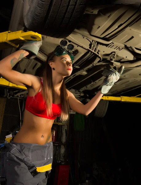Krásná mladá žena mechanik kontrolní auto v auto-servis. Sexy mechanik — Stock fotografie