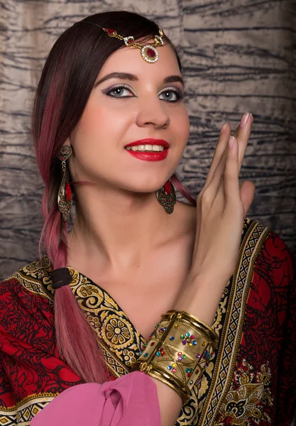 Крупный план красивой кавказской женщины в восточном стиле с восточными узорами на руках и лице, с многочисленными браслетами — стоковое фото