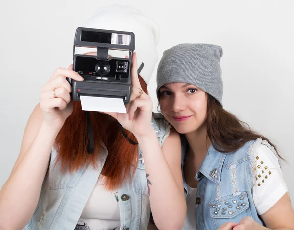 Beleza hipster meninas preto e vermelho em óculos de sol, fazendo foto em instantâneos da câmera. adolescentes grimace — Fotografia de Stock