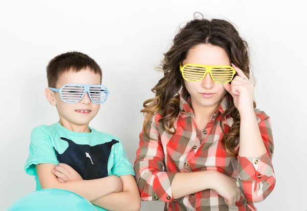 Brother and sister, wearing glasses in the style of disco. fold ones arms — 图库照片