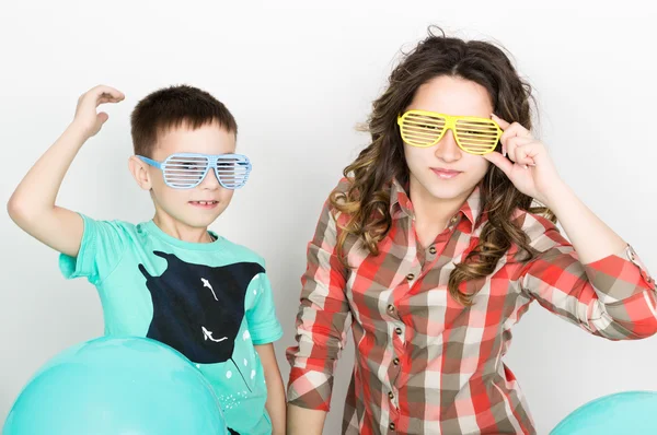 Brother and sister, wearing glasses in the style of disco. fold ones arms — 图库照片