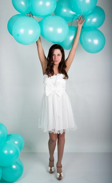 Linda menina encaracolado em um vestido branco e óculos de sol no estilo de disco jogando com balões — Fotografia de Stock