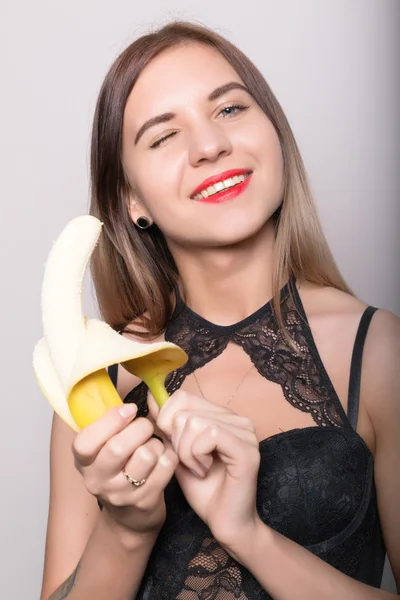 Jonge vrouw in kanten lingerie houden een banaan verbaasd, she's gonna een banaan eten — Stockfoto