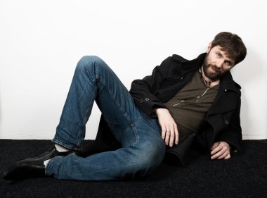 Yakışıklı sakallı zarif iş adamı bir ceket, kot pantolon ve yünlü ceket poz. feshion kavramı