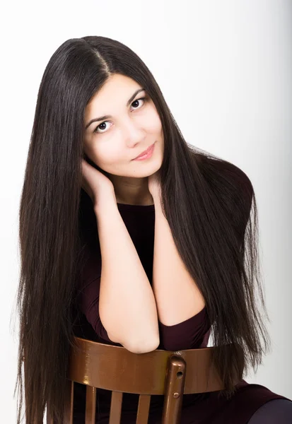 아름다운 아시아의 젊은 갈색 머리에 어두운 드레스 앉아 에 a 의자 — 스톡 사진
