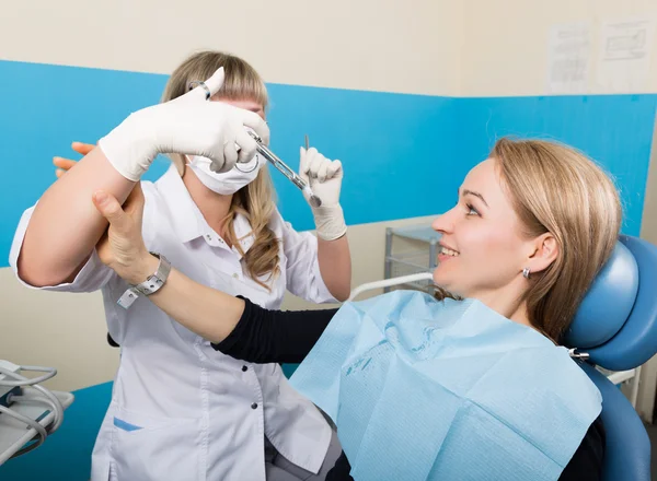 El médico examina la cavidad oral en la caries dental. Protección contra caries. Tratamiento de caries dental. El médico inyecta al paciente, el paciente toma la mano del médico y no le pone una inyección. — Foto de Stock