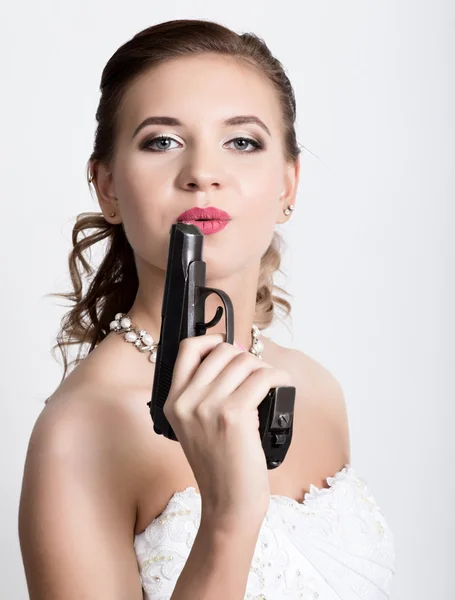 Hermosa novia con peinado de boda de moda. Retrato de cerca de la joven novia hermosa. Novia sosteniendo un arma — Foto de Stock