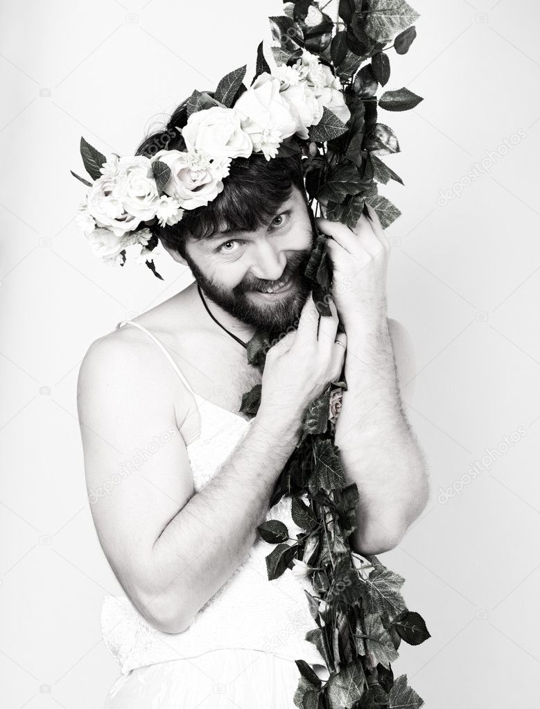 bearded man in a womans wedding dress on her naked body, clinging to the vine. on his head a wreath of flowers. funny bearded bride, black and white