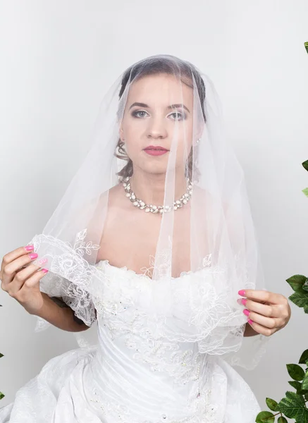 Hermosa novia con peinado de boda de moda. Retrato de cerca de la joven novia hermosa. Boda, cara de las niñas es velo oculto —  Fotos de Stock