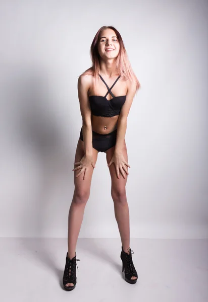 Piernas delgadas hermosa chica sexy en un sujetador y bragas de encaje negro en tacones altos, posando — Foto de Stock