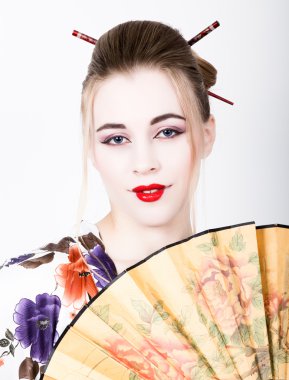 güzel kız, bir geyşa gibi giyinmiş o Çin hayranı sahiptir. Geyşa makyaj ve saç bir kimono giymiş. Geleneksel Japon değerler kavramı