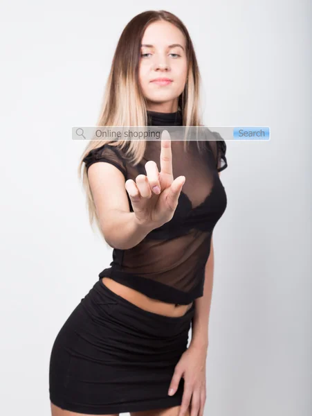 Online shopping written in search bar on virtual screen. Internet technologies in business and home. girl in black skirt and top, presses a finger on a virtual screen — Stock Photo, Image