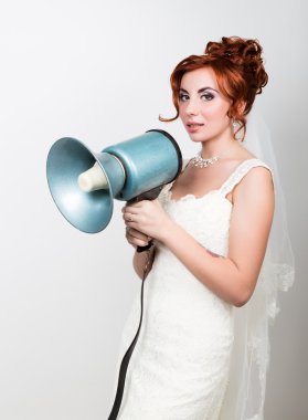 beautiful bride in a wedding dress with a wedding makeup and hairstyle, she yells into a bullhorn. Public Relations clipart