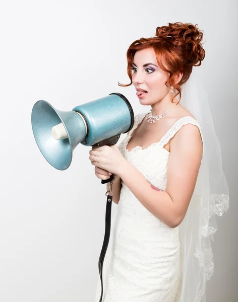 Hermosa novia en un vestido de novia con un maquillaje de boda y peinado, ella grita en un megáfono. Relaciones públicas — Foto de Stock