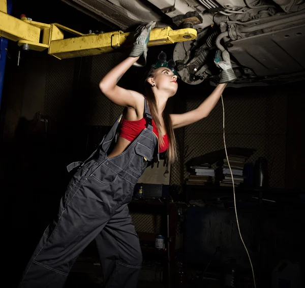 Piękne młode kobiece mechanik dokonujące kontroli samochodu w auto warsztat. Seksowny mechanik — Zdjęcie stockowe