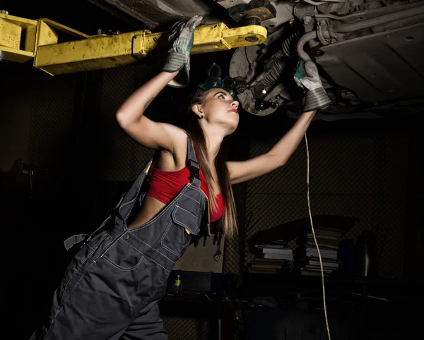 Piękne młode kobiece mechanik dokonujące kontroli samochodu w auto warsztat. Seksowny mechanik — Zdjęcie stockowe