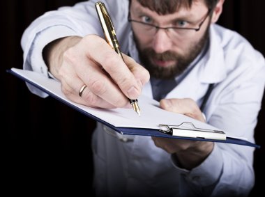 yakın çekim yakışıklı bir tıp doktoru doktor bir tanıtıcı belgeleri imzalar. Doktor tıbbi geçmişi yazıyor. bir reçete hasta veri tarih yazmak